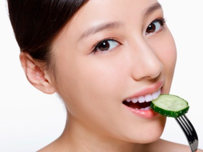 The image features the woman eating pickles as a means to maintaining her glow naturally.  