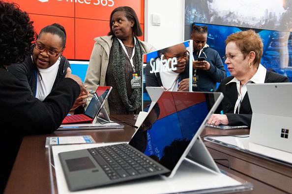 Customers examine the Microsoft Surface at Microsoft's first flagship store on Fifth Avenue on October 26, 2015 in New York City. Hundreds of eager customers waited outside to celebrate the opening of the three-story store that sells everything from lapto