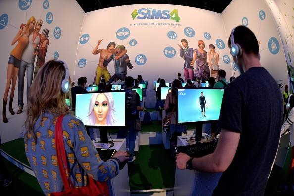 Visitors try out the game 'SIMS 4' at the Electronic Arts stand at the 2014 Gamescom gaming trade fair on August 14, 2014 in Cologne, Germany. Gamescom is the world's largest gaming convention and this year includes over 600 exhibitors. 