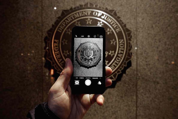 The official seal of the Federal Bureau of Investigation is seen on an iPhone's camera screen outside the J. Edgar Hoover headquarters