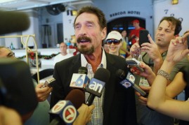 John McAfee talks to the media outside Beacon Hotel where he is staying after arriving last night from Guatemala on December 13, 2012 in Miami Beach, Florida. 