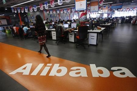 An employee walks past a logo of Alibaba Group at its headquarters in the Zhejiang province