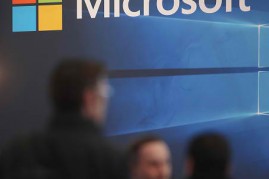 People walk past the Microsoft stand at the 2016 CeBIT digital technology trade fair on the fair's opening day on March 14, 2016 in Hanover, Germany.