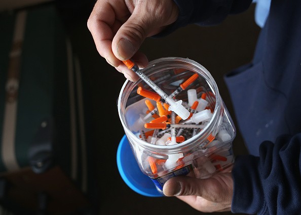 A drug user takes a needle before injecting himself with heroin on March 23, 2016 in New London, CT. 
