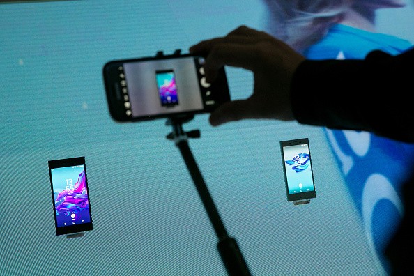 A visitor uses a smartphone device to take a photograph of the Xperia XZ, left, and Xperia X compact smartphones during a news conference on the Sony Corp. exhibition stand during the IFA International Consumer Electronics Show in Berlin, Germany, on Thur