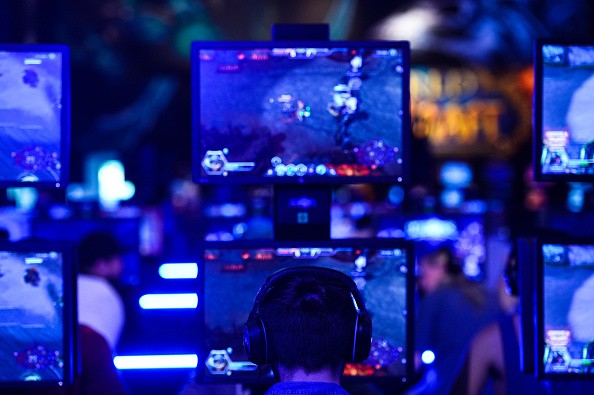 Visitors try out the game 'World Of Warcraft' at the Blizzard Entertainment stand at the Gamescom 2015 on August 5, 2015 in Cologne, Germany. 