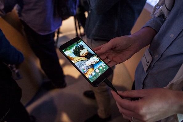 Members of the media examine Google's Pixel phone during an event to introduce Google hardware products on October 4, 2016 in San Francisco, California.