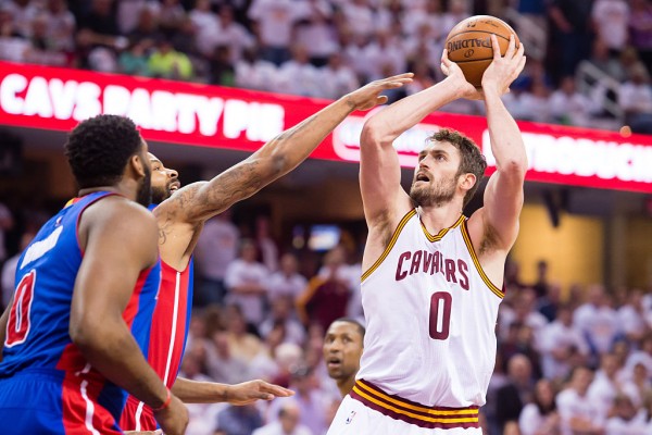 Cleveland Cavaliers power forward Kevin Love (R) shoots over two Detroit Pistons players