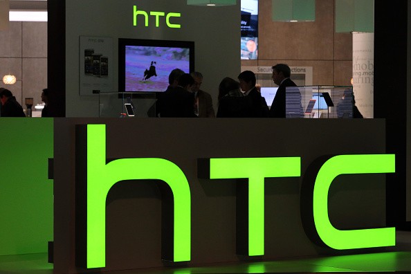 Logos sit illuminated at the HTC Corp. pavilion during the Mobile World Congress at the Fira Gran Via complex in Barcelona, Spain on February 27, 2014.