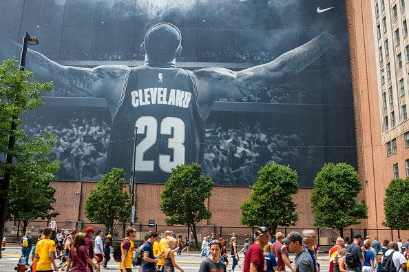 Cleveland fans walk in front of a LeBron James mural located on Ontario St. during the Cleveland Cavaliers 2016 NBA Championship victory parade and rally on June 22, 2016 in Cleveland, Ohio.
