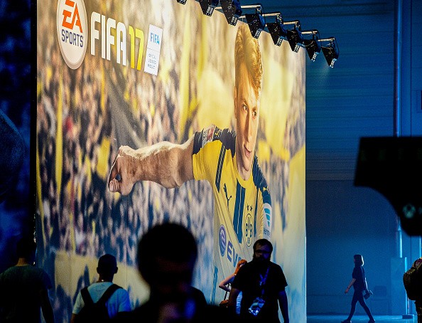  Visitors stands in front of the EA Sports stand at the Gamescom 2016 gaming trade fair during the media day on August 17, 2016 in Cologne, Germany. 