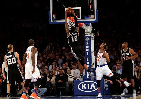 LaMarcus Aldridge #12 of the San Antonio Spurs slam dunks the ball in front of Derrick Williams #23 of the New York Knicks during the first quarter at Madison Square Garden on November 2, 2015 in New York City.