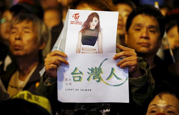 A supporter of Tsai Ing-wen holds up a poster of Taiwanese K-pop singer Chou Tzuyu at their party headquarters.