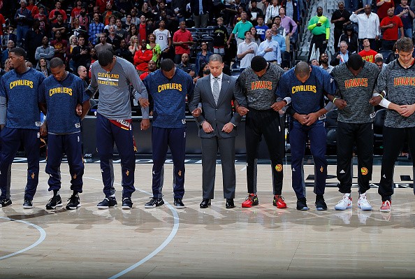Player and coaches for the Cleveland Cavaliers and Atlanta Hawks stand together during the National Anthem prior to their game at Philips Arena on October 10, 2016 in Atlanta, Georgia. 