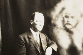 A man's blurred face appears next to the sitter, surrounded in an ethereal-looking 'mist'. The signature in the upper right hand corner belongs to the sitter.
