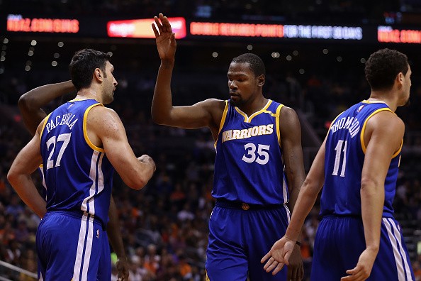 Kevin Durant #35 of the Golden State Warriors high fives Zaza Pachulia #27 after scoring against the Phoenix Suns during the first half of the NBA game at Talking Stick Resort Arena on October 30, 2016 in Phoenix, Arizona. 