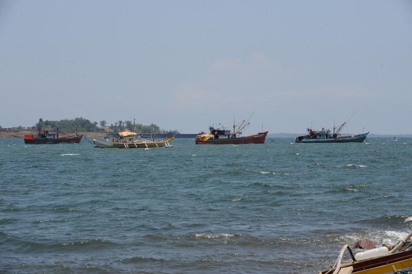 Fishing boats (2nd L, and at left) also locally known as 'mother boats' which are used to transport fish caught around Scarborough shoal, are anchored off Santa Cruz bay, Zambales province, north of Manila, facing south China sea (back) on May 10, 2012, a