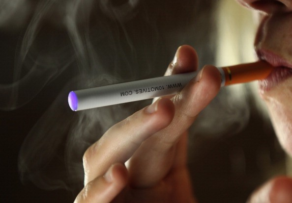 In this photo illustration a woman smokes an electronic cigarette on July 5, 2012 in Knutsford, United Kingdom. Electronic cigarettes are the latest health device for smokers hoping to quit nicotine addiction. 