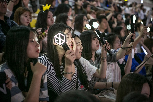 EXO-Ls getting emotional while watching their idols perform during a concert in South Korea.