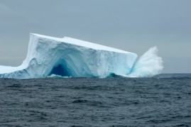 Antarctica, Scotia Sea, Near South Georgia, Waves Crashing On Tabular Iceberg With Cave.