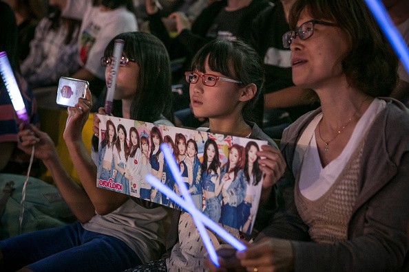Young fans cheer on IOI during their performance at a K-Pop concert in Seoul.