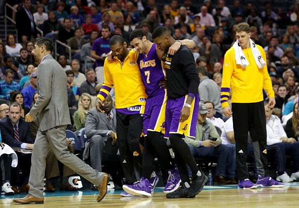 Larry Nance Jr. #7 of the Los Angeles Lakers is carried off the floor after an injury against the Charlotte Hornets during their game at Spectrum Center on December 20, 2016 in Charlotte, North Carolina. 