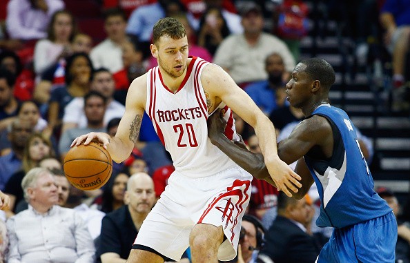 Donatas Motiejunas #20 of the Houston Rockets drives with the basketball against Gorgui Dieng #5 of the Minnesota Timberwolves during their game at the Toyota Center on March 18, 2016 in Houston, Texas.  
