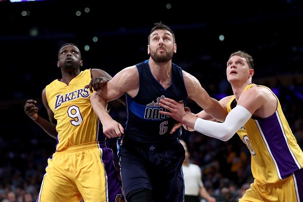 Timofey Mozgov #20 and Luol Deng #9 of the Los Angeles Lakers box out Andrew Bogut #6 of the Dallas Mavericks during the first half of a game at Staples Center on November 8, 2016 in Los Angeles, California