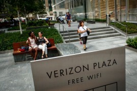 People walk by Verizon Plaza outside the Verizon headquarters building on July 25, 2016 in New York City. Verizon Communications has announced it is buying Yahoo's core businesses for $4.83 billion.