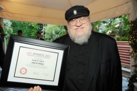 Writer George R. R. Martin poses with the Year of Excellence Award for 'Game of Thrones'