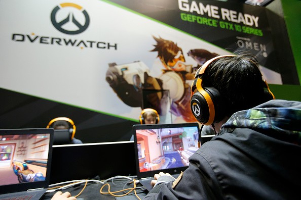 A gamer with a headphone plays the video game 'Overwatch' developed by Blizzard Entertainment and published by Action Blizzard during the 'Paris Games Week' on October 28, 2016 in Paris, France