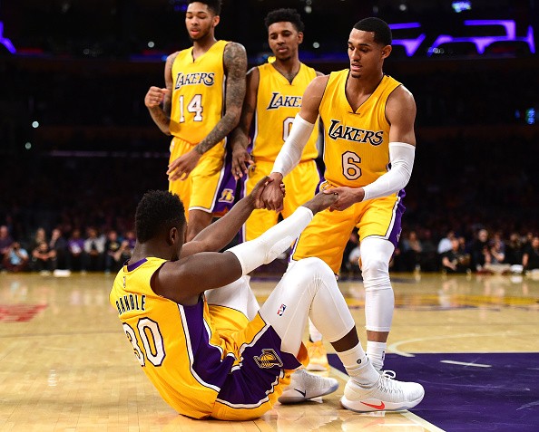 Julius Randle #30 of the Los Angeles Lakers gets helped up by Jordan Clarkson #6 as Nick Young #0 and Brandon Ingram #14 look on during a 101-89 Dallas Mavericks win at Staples Center on December 29, 2016 in Los Angeles, California. 