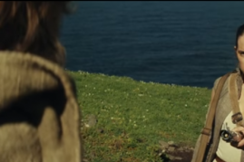 Rey hands Luke Skywalker his lightsaber in a scene from 