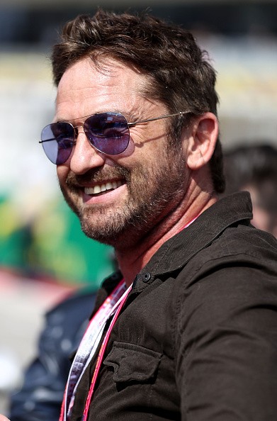Actor Gerard Butler smiled next to the Red Bull Racing team on the grid before the United States Formula One Grand Prix at Circuit of The Americas on Oct. 23, 2016 in Austin, United States. 