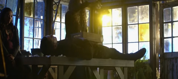 Enzo lies dead while Bonnie looks heartbroken in a scene from "The Vampire Diaries" Season 8 finale.