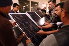 Students move photovoltaic panels during a solar panel installation course at City College of San Francisco March 26, 2009 in San Francisco, California.