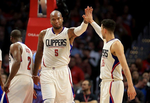 Austin Rivers congratulates Marreese Speights of the LA Clippers during the first half of a game against the Denver Nuggets at Staples Center on December 20, 2016 in Los Angeles, California. 