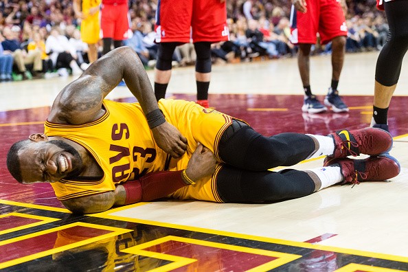 LeBron James is taking a hard hit during the second half against the Washington Wizards at Quicken Loans Arena on March 25, 2017 in Cleveland, Ohio. 