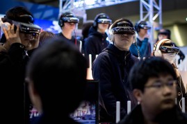 People watch a concert on virtual reality headsets at a booth during the Anime Japan 2015 Expo on March 21, 2015 in Tokyo, Japan. 
