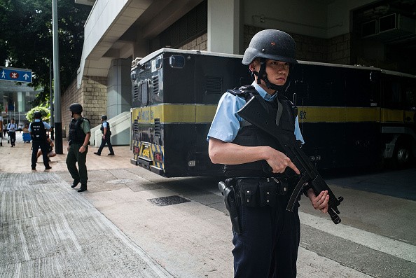 Hong Kong police officers stand guard around a prison vehicle.  