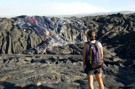 Hiker Gigi Galong, of Kona, watches the lava flow in Volcano National Park. On July 27 Kilauea's lava flow increased resulting in additional forest fires within the park