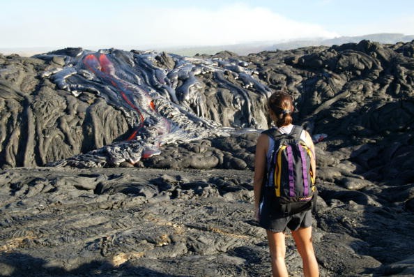 Hiker Gigi Galong, of Kona, watches the lava flow in Volcano National Park. On July 27 Kilauea's lava flow increased resulting in additional forest fires within the park