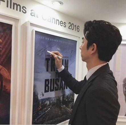 South Korean actor Gong Yoo signs movie poster of "Train to Busan" at Cannes Film Festival.