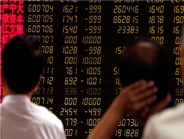 Investors wait for China's stock market to open in front of an electronic board at a brokerage house in Beijing, China.