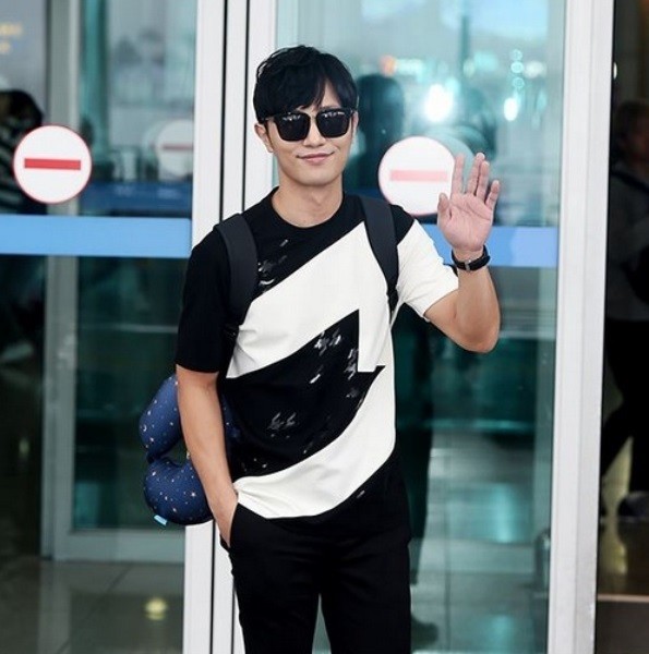 Jin Goo is waving at his fans.