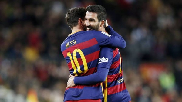 Barcelona midfielder Arda Turan (R) shares a hug with teammate Lionel Messi