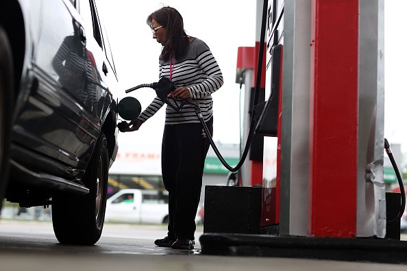 Josephina Romano   fills her vehicle with gas at a U-Gas station on   October 19, 2015 in Miami, Florida. 