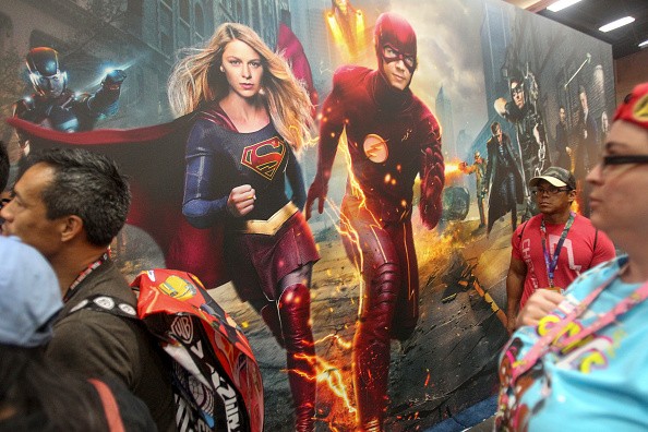onvention-goers saunter by as Supergirl and The Flash jump pff a mural during Comic-Con International 2016 in San Diego, California on July 21, 2016. 