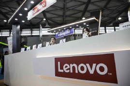 Exhibitors sit behind a counter at the Lenovo Group Ltd. booth at the Mobile World Congress Shanghai in Shanghai, China.