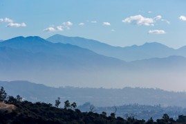 The San Gabriel mountains above Los Angeles with an inversion layer of dirty air, smog. SB 350 signed in to law. California Governor Jerry Brown signing SB 350, the climate and clean energy legislation bill